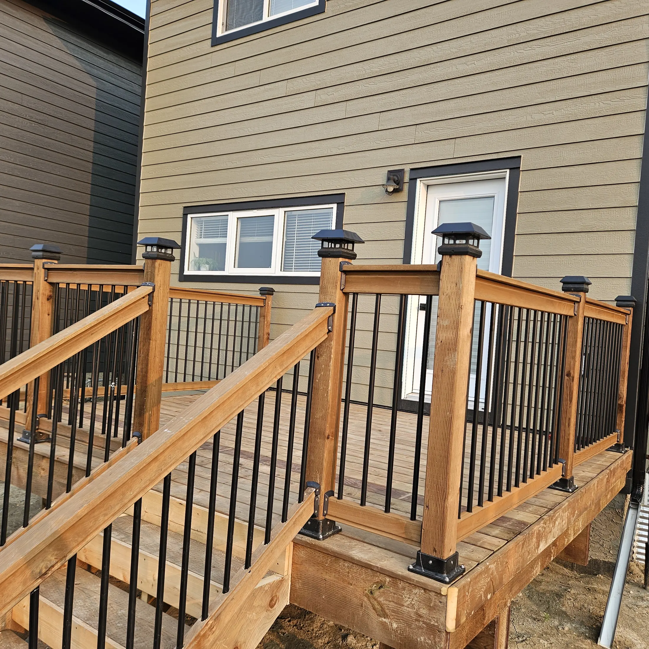 Completed wood deck landing and railings outside a Rosewood home