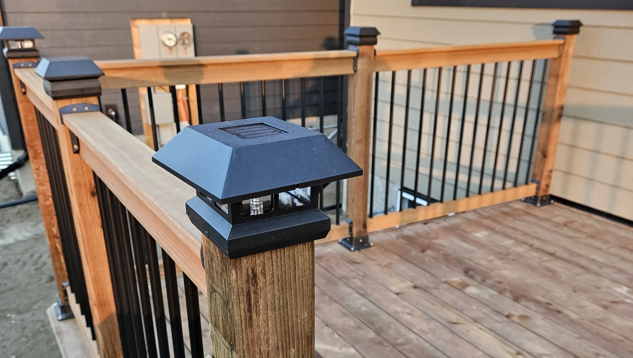 Close view of a black solar post light on the completed wood deck railing