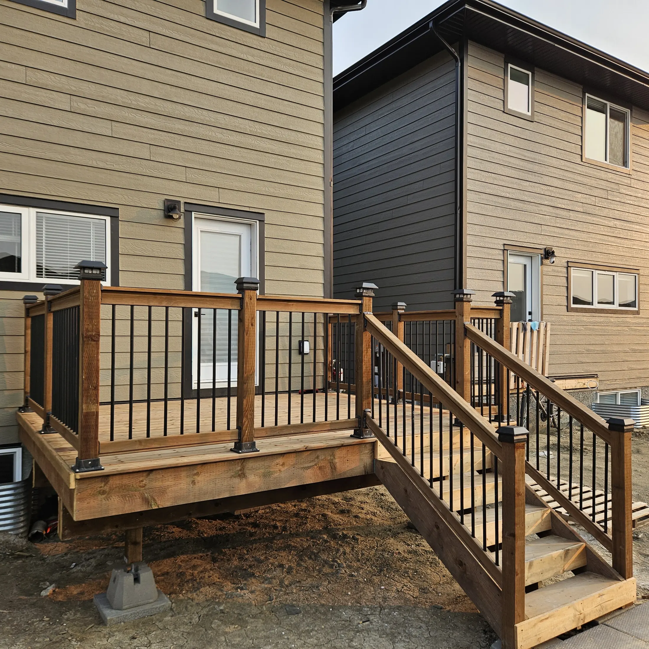 Completed Rosewood backyard deck showing the stairs, landing, and black railings